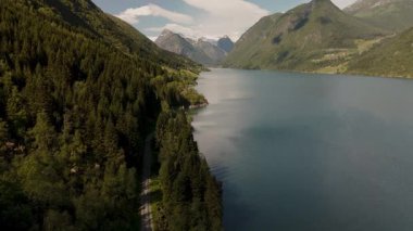 Norveç 'in bereketli ormanları ve yüksek dağlarıyla çevrili, kıvrımlı Sognefjord Gölü' nün sakin güzelliğini keşfedin. Huzurlu atmosfer sizi rahatlamaya ve doğanın ihtişamının tadını çıkarmaya davet ediyor..