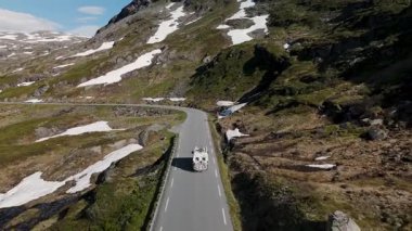 Norveç 'te dolambaçlı bir yol boyunca heybetli dağlar ve karlarla çevrili çarpıcı bir yolculuk. Norveç 'in 63 no' lu karayolu üzerinde bir karavan, Geiranger Trol stigen Langvatnet rotası, Norveç
