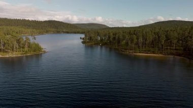 Norveç 'te yuva yapmış sakin bir göl çevresini çevreleyen yemyeşil ağaçları yansıtır. Yumuşak dalgalar, berrak bir gökyüzünün altında kıyıya doğru süzülür. Bu el değmemiş vahşi doğayı rahatlatmak ve keşfetmek için davet edilir..