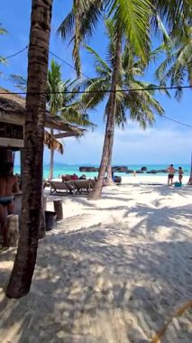 Ziyaretçiler Tayland 'daki Koh Kham Adası' nın yumuşak beyaz kumları ve kristal berrak sularının tadını çıkarıyorlar. Palmiye ağaçları, insanlar rahatlarken ve güneşin altındaki adalarda doğal güzelliklerle eğlenirken yavaşça sallanır..