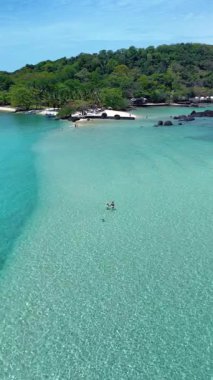 Tayland 'daki Koh Kham Adası' nın nefes kesen turkuaz sularını keşfedin. Güneşli bir günde iki birey huzurlu çevreden ve nazik dalgalardan keyif alır..