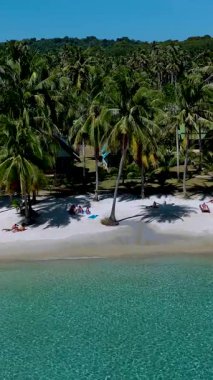 Koh Kood Tayland 'daki çarpıcı bir tropik plajın sakin atmosferini hissedin. Parlak güneş ışığında sallanan palmiye ağaçlarının altındaki yumuşak beyaz kumda rahatla..