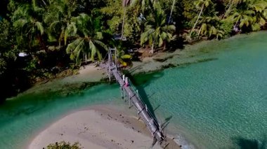Koh Kood Tayland 'da, yemyeşil sulara açılan çarpıcı ahşap bir köprüyü gösteren pitoresk bir yer keşfedin. Rahatlama ve keşif için ideal..