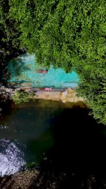 Ziyaretçilerin canlı yeşilliklerle çevrili doğal bir havuzun berrak mavi sularının tadını çıkarırken kendinizi sakin bir tropikal ortama daldırın, Tayland 'da rahatlamanın özünü yakalayın..