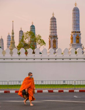 20 Ocak 2025 'te Bangkok Tayland' da bir keşiş, Bangkok 'un sakin alacakaranlığı sırasında büyüleyici Tayland mimarisi tarafından çevrelenmiş Wat Phra Kaew' da sessiz bir cadde boyunca çıplak ayakla turp gezintisine çıktı..