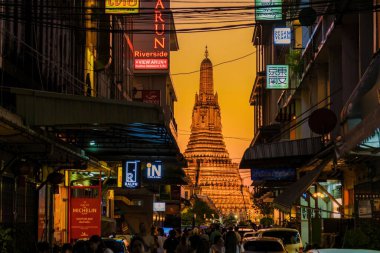 Bangkok Tayland 20 Ocak 2025, Wat Arun 'un görkemli silueti Bangkoks sokaklarını aydınlatıyor. Renkli işaretler canlı bir atmosfer yaratıyor, dinamik enerjiyi gözler önüne seriyor..
