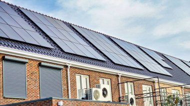 Çağdaş ikamet, Hollanda 'da etkin bir çevre dostu yaşam için güneş enerjisini kullanan parlak siyah güneş panellerinin yanına kurulmuş bir hava kaynağı ısı pompası içermektedir..