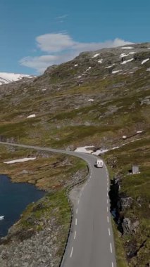 Norveç 'in çarpıcı güzelliğini görkemli dağların ve sakin göllerin arasında dolambaçlı yollarla keşfedin. Doğanın özünü deneyimleyin. Yolculuk açık mavi bir gökyüzü altında devam ediyor..