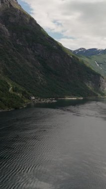 Norveç ikonik fiyortlarının sakin sulara yansıyan sarp dağlarla nefes kesici manzarası. Bu dingin ortam, Norveç 'in doğal güzelliğini mükemmel bir uyum içinde yansıtıyor..