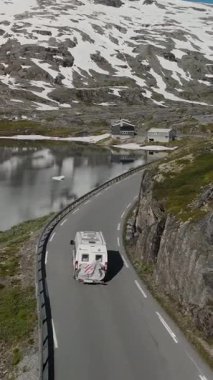 Norveç 'in çarpıcı yollarını keşfedin. Bir karavan, görkemli dağlar ve sakin sularla çevrili dolambaçlı yollarda gezinir. İlçe Yolu 63, Geiranger Trol stigen Langvatnet rotası, Norveç