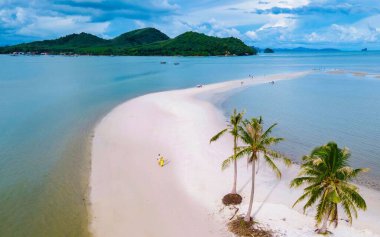Koh Yao Yai 'nin çarpıcı kıyılarında, çiftler sallanan palmiye ağaçları ile tropikal atmosferin tadını çıkararak beyaz kumlu plajlarda geziniyorlar. Bu cennet gibi ada manzarası romantik bir kaçış sunuyor..