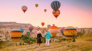 Goreme, Cappadocia 'nın göz kamaştırıcı manzarasında, bir çift canlı gündoğumuna hayran..
