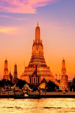 Wat Arun, Chao Phraya nehrine güzel bir şekilde yansıyan canlı alacakaranlık gökyüzüne karşı dimdik ayakta duruyor. Karmaşık mimari ve sakin ortam ziyaretçileri güzelliğini keşfetmeye davet ediyor..