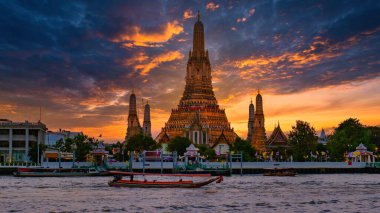 Wat Arun, güneş Bangkok 'un üzerinde görkemli bir şekilde batarken nehirden sıcak renkler döküyor. Tekneler huzur içinde sürükleniyor, sakin nehir kenarı atmosferini ve çarpıcı mimariyi geliştiriyor..