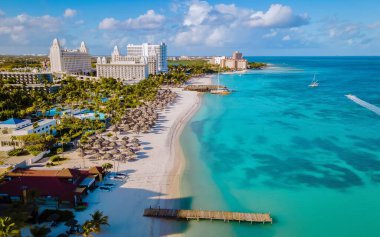 Yumuşak beyaz kumların kristal berrak turkuaz sularla buluştuğu Aruba 'daki Palm Beach' in nefes kesici manzarasını keşfedin..