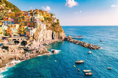 Manarola 'nın canlı binaları, İtalya' daki Ligurya Denizi 'nin parlak mavi sularına bakan engebeli kayalıklara tutunuyor.