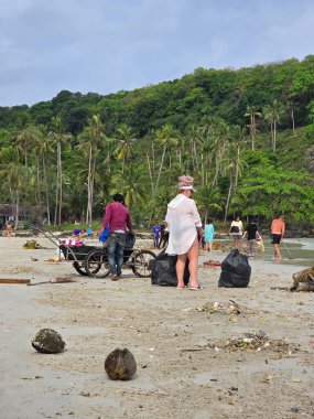Koh Kood, Tayland, 13 Mart 2025. Yerel halk, bir temizlik etkinliğine katılmak üzere güneşli plajda toplandı..