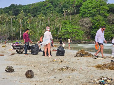 Koh Kood, Tayland, 13 Mart 2025. Gönüllüler el değmemiş çevreyi korumak için kumlu kıyılarda çöp topluyor. Turistler çöp ve plastik topluyor.