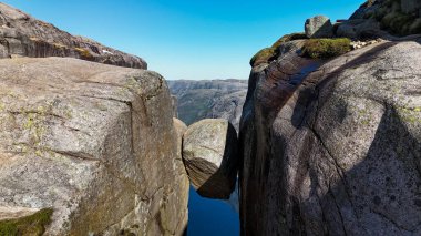 Büyük bir kayanın granit kayalıklar arasında dengelendiği Norveç 'teki büyüleyici kaya oluşumlarını araştırın. Kjeragbolten Lysefjord, Norveç