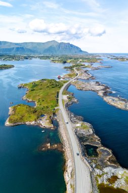 Norveç 'te, yemyeşil manzaralar ve ışıl ışıl mavi sularla çevrili dolambaçlı bir kıyı yolunun çarpıcı manzarasının tadını çıkarın. Atlantik Okyanusu Yolu, Norveç