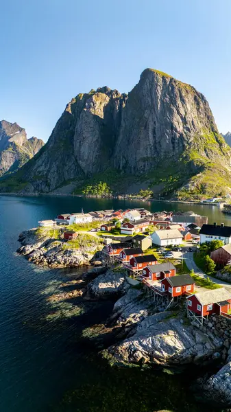 Göz kamaştırıcı dağların arasına yerleştirilmiş, sakin kıyı şeridi boyunca geleneksel kırmızı kulübelere ev sahipliği yapıyor. Hamnoy, balıkçı köyü Lofoten, Norveç