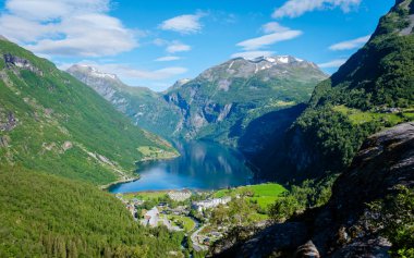 Sersemletici panoramik manzara Geirangerfjord, yüksek dağlarla yemyeşil arasında yer alıyor. Parlak manzara, güneşli bir günde Norveç 'in doğal güzelliğini ve huzurunu gözler önüne seriyor..