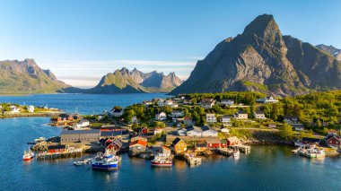Canlı tekneler Reine limanında, çarpıcı tepeler ve kristal berrak sularla çevrili. Norveç 'teki bu büyüleyici balıkçı köyü gün doğumunda nefes kesici manzaralar ve sakin bir atmosfer sunuyor..