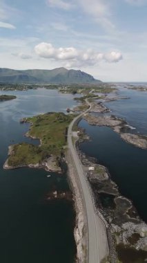 Engebeli kayalıkları ve sakin suları kucaklayan dolambaçlı bir yolu barındıran Norveç kıyı manzarasının çarpıcı güzelliğini keşfedin. Atlantik Okyanusu yolu Norveç