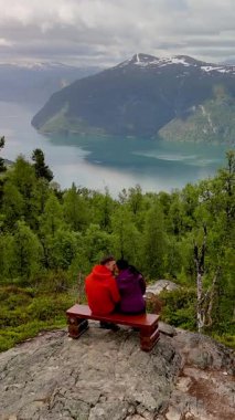 Yeşillik ve görkemli dağlarla çevrili muhteşem bir fiyorda bakan bir çift bankta oturuyor. Molden Norveç 'in sakinliği romantik anları için mükemmel bir zemin sağlar..