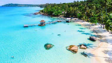 Bu nefes kesici tropikal sahil, Koh Kood Tayland tropikal adasında sallanan palmiye ağaçları ile çevrili el değmemiş turkuaz suları ve yumuşak beyaz kumları barındırır.
