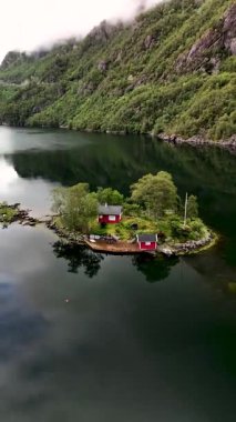 Norveç 'te yemyeşil ve sakin sularla çevrili kırmızı kulübelerin nefes kesici manzarasını keşfedin. Bu huzurlu ortam güzelliği ve sükuneti gözler önüne seriyor. Kaçış ve rahatlama için mükemmel..