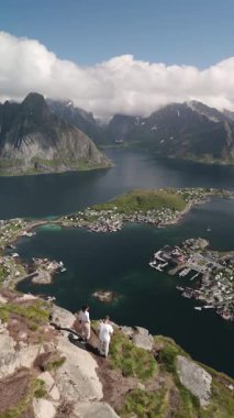 Reinebringen yürüyüşünün keyfini çıkarın. Lofoten Norveç engebeli dağları, derin fiyortları ve su kenarındaki büyüleyici köyü..