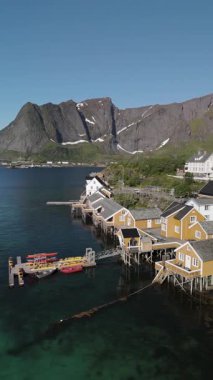 Sahil şeridi boyunca yuva yapmış canlı ahşap kulübelerin bulunduğu pitoresk bir Norveç köyünün cazibesini deneyin. Lofoten Norveç