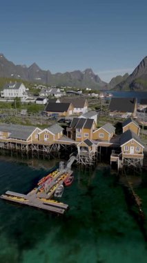 Geleneksel ahşap evler, görkemli dağlara ve berrak mavi sulara karşı kurulmuş, sakin ve huzurlu bir atmosfer yaratan pitoresk bir Norveç köyünün kıyılarına dizilmiştir. Lofoten Norveç