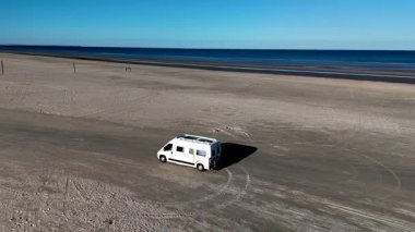 Romo Lakolk 'ta sakin bir plaj sahili sahili kumlu sahilde bir karavan kullanıyor. Uçsuz bucaksız ufuk sakin sularla buluşuyor, Danimarka 'daki bu doğal mücevheri rahatlatmak ve keşfetmek için..