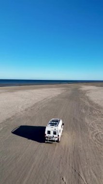 Romo Danimarka Lakolk plajında sakin bir gün. Açık mavi gökyüzü altında geniş kumlu manzaralar var. Bir kampçı sahilde geziyor, plaj aşıkları ve maceracılar için mükemmel bir dinlenme yeri yaratıyor..
