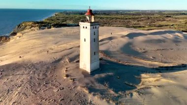 Danimarka 'nın Jutland bölgesindeki Knude Fyr Deniz Feneri' nde altın kum tepelerinin birleştiği muhteşem Rubjerg Knude Fyr deniz fenerini keşfedin. Resimli bir kule sakin sahile bakıyor, keşif ve rahatlamaya davetiye çıkarıyor..