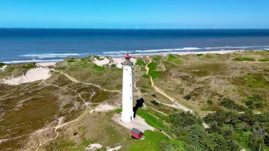 Muhteşem Lyngvig Deniz Feneri Hvide Sande 'yi keşfedin. Danimarka, Jutland' da altın kumların canlı mavi sularla buluştuğu yerde..