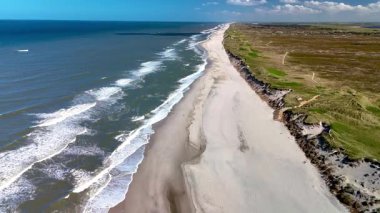 Dalgalar Danimarka 'nın Jutland kentindeki Rubjerg Knude Fyr Deniz Feneri' nin kumlu kıyılarına hafifçe vurur.