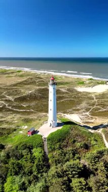 Ziyaretçiler Lyngvig Deniz Feneri Hvide Sande 'nin altın kumlarını keşfeder Gün aydınlık ve berrak, maceraperestleri doğanın cazibesine davet eder.