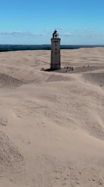 Danimarka 'nın Jutland kentindeki Rubjerg Knude Fyr Deniz Feneri' nin açık mavi gökyüzünün altındaki nefes kesici kumullarını deneyin..