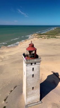 Danimarka 'nın Jutland kentindeki Rubjerg Knude Fyr Deniz Feneri' nde kumlu kıyılara bakan büyüleyici bir deniz feneri ve sakin bir deniz, plaj aşıkları ve doğa meraklıları için ideal..