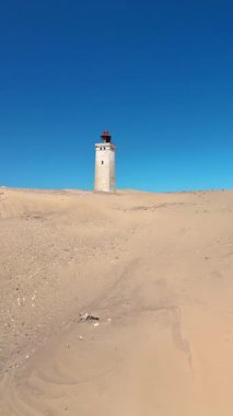 Jutland, Danimarka 'nın canlı kıyı şeridi boyunca uzanan Rubjerg Knude Fyr Deniz feneri eşsiz bir kum tepeciği ve pitoresk bir deniz feneri karışımı sunuyor..