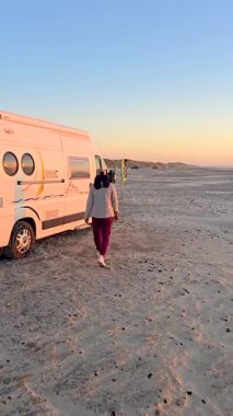 Danimarka 'nın Jutland sahilindeki Lakolk otomobil plajında rahat bir akşam yürüyüşü. Altın gün batımı sahnenin üzerine ılık bir parıltı saçar. Deniz kıyısında keşif ve sükuneti davet eder..