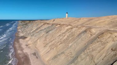 Danimarka 'nın Jutland bölgesindeki Rubjerg Knude Fyr Deniz Feneri' nin nefes kesici manzarası kumullarını ve dalgalarını gözler önüne seriyor. Ziyaretçiler deniz fenerinin dingin atmosferinin keyfini çıkarırken,