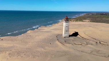 Rubjerg Knude Fyr Deniz Feneri. Altın kumların Atlantik Okyanusu 'yla buluştuğu yer. Eski deniz feneri gururla durur, Danimarka 'da rahatlama ve macera dolu bir gün için mükemmel bir zemin oluşturur.