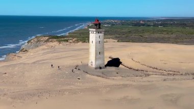 Rubjerg Knude Fyr Deniz fenerinin güzelliğini keşfedin. Danimarka, Jutland 'da altın kumların Kuzey Denizi dalgalarıyla buluştuğu yerde.. 