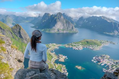 Bir yürüyüşçü Norveç 'in görkemli dağları ve kristal berrak sularıyla çevrili nefes kesici Lofoten adalarına bakar. Sahne, macera ve sükunetin özünü yakalar..