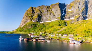 Lofoten Norveç 'te güneş ışığıyla yıkanmış dramatik dağlarla çevrili büyüleyici bir sahil köyünü keşfedin..