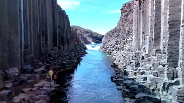 Studlagil Kanyonu İzlanda 'nın nefes kesici güzelliğini deneyimleyin. Orada yükselen bazalt sütunlar huzurlu nehri çerçeveler..